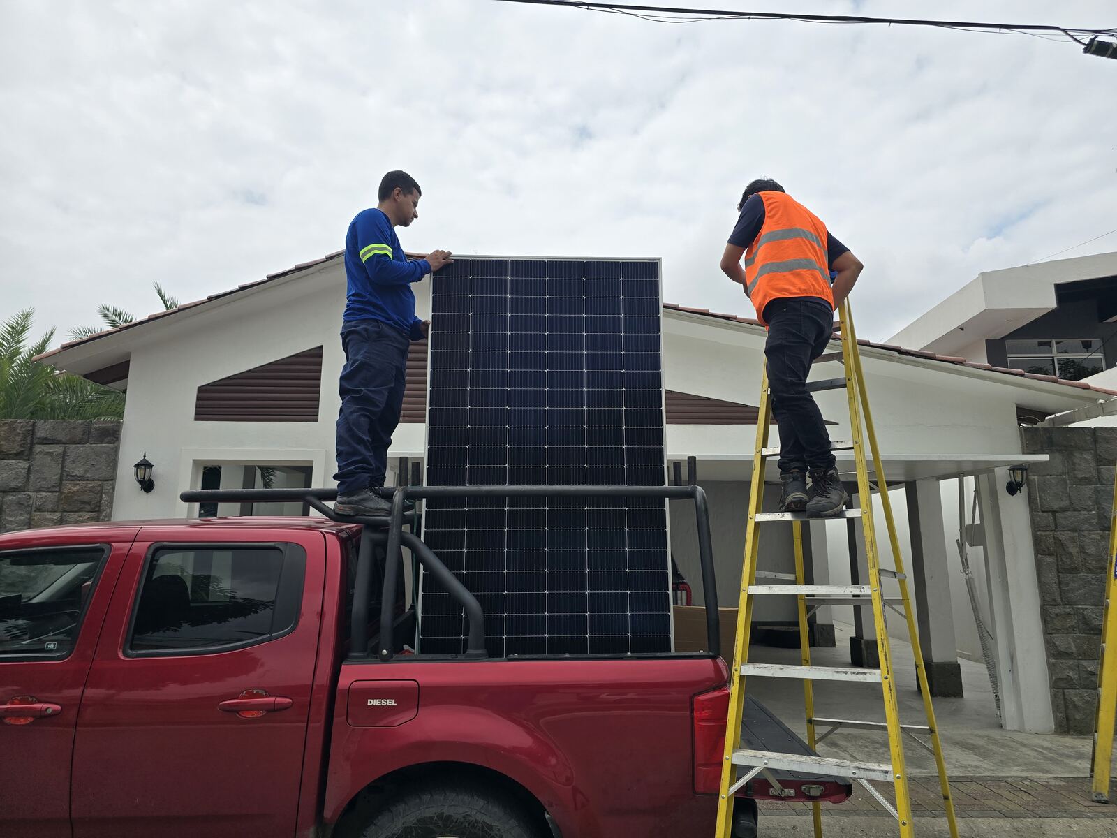 Técnicos de IPS instalando un panel solar en Ecuador